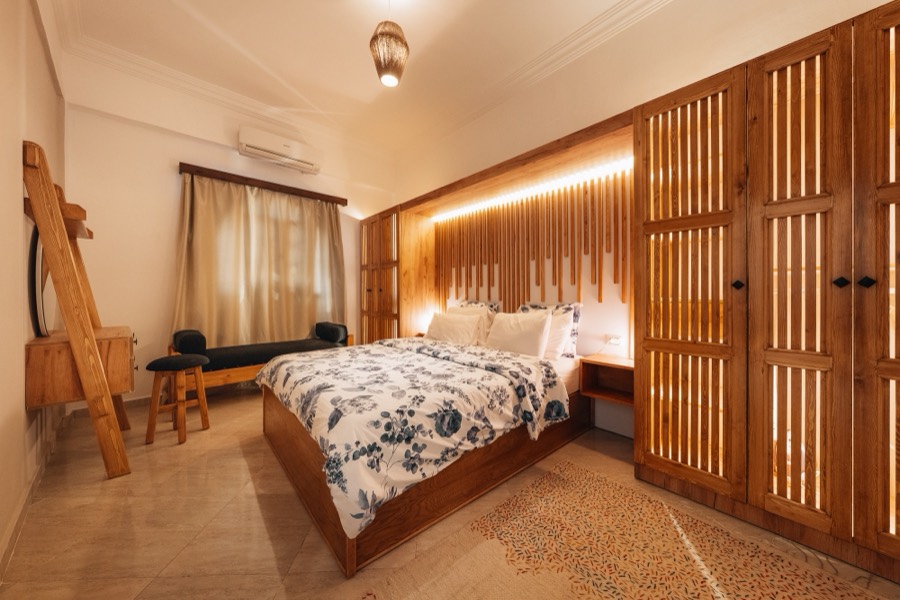Bedroom with a slatted wood headboard wall