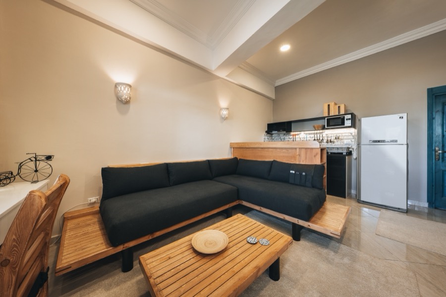Living room with a deep sectional sofa and open kitchen behind